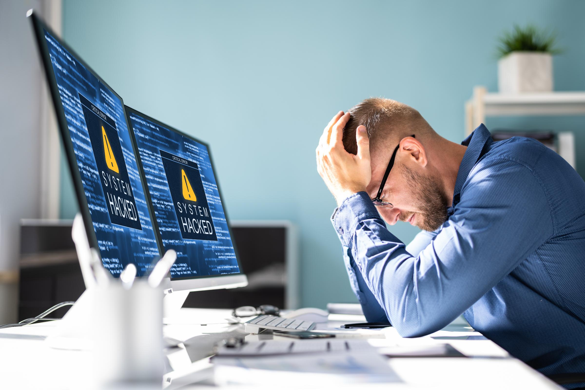 Overwhelmed professional dealing with system downtime and IT problems, illustrating challenges solved by Waterdog Technology Solutions managed IT services.