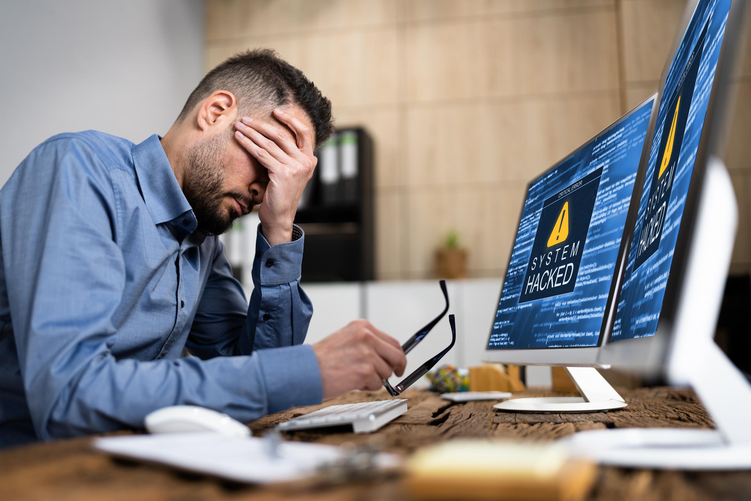 Employee frustrated by computer and cybersecurity issues, highlighting the need for proactive IT support from Waterdog Technology Solutions.