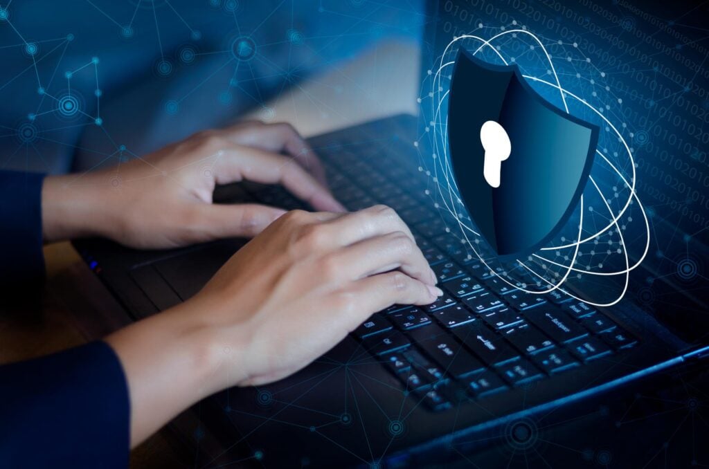 Hands typing on a keyboard with digital security lock icon, symbolizing cybersecurity protection and data security services by Waterdog.